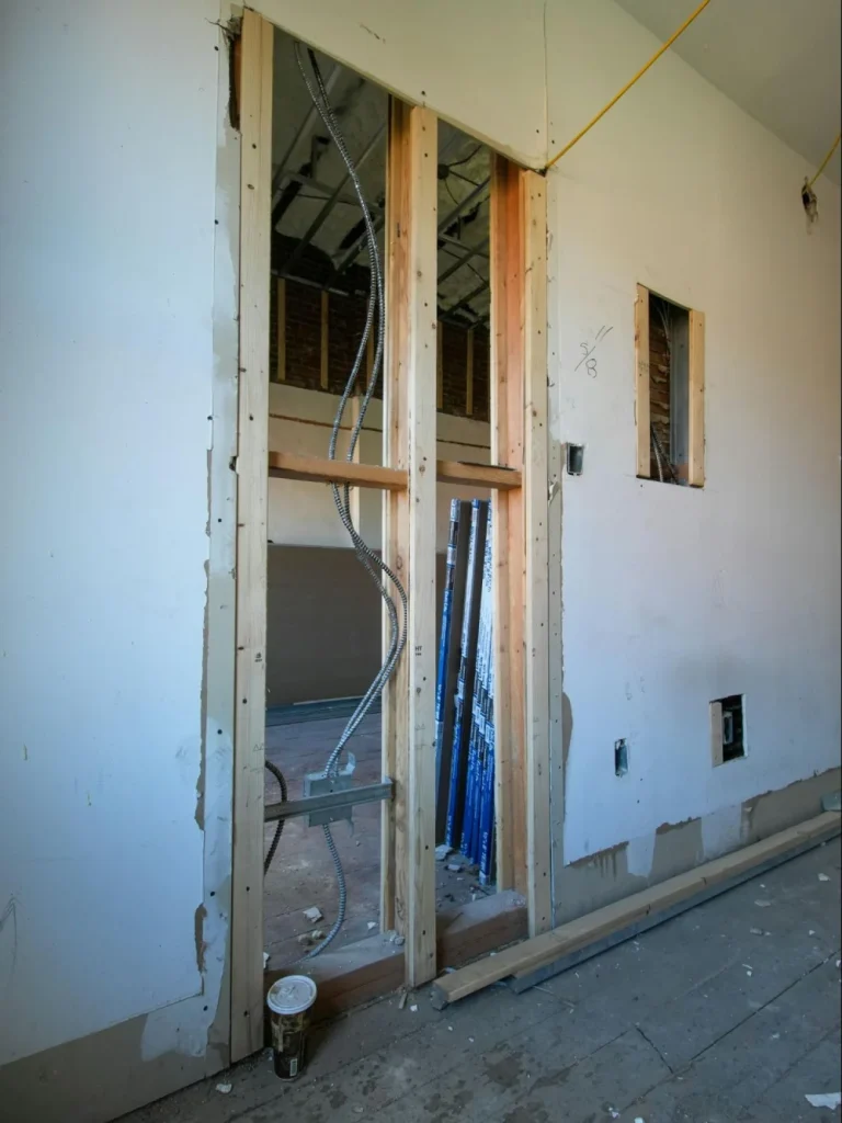 Wall opening framed with timber studs during a load-bearing wall removal